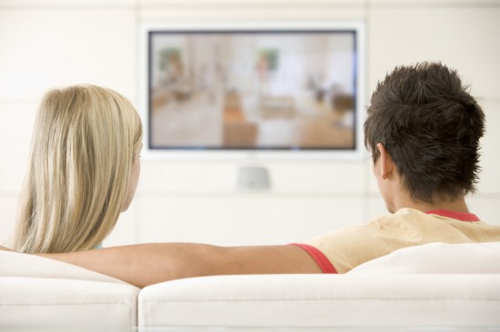 Couple in living room watching television